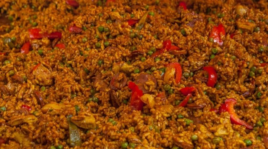 Close-up of chicken chorizo paella with rice, red peppers, and green peas