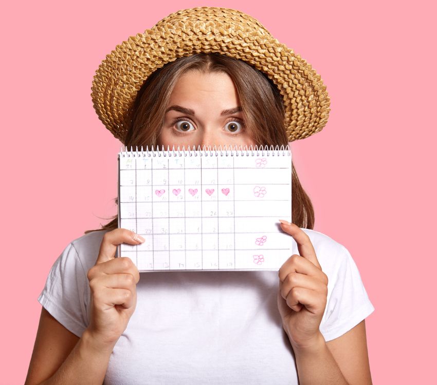 Woman holding a calendar with a pink background